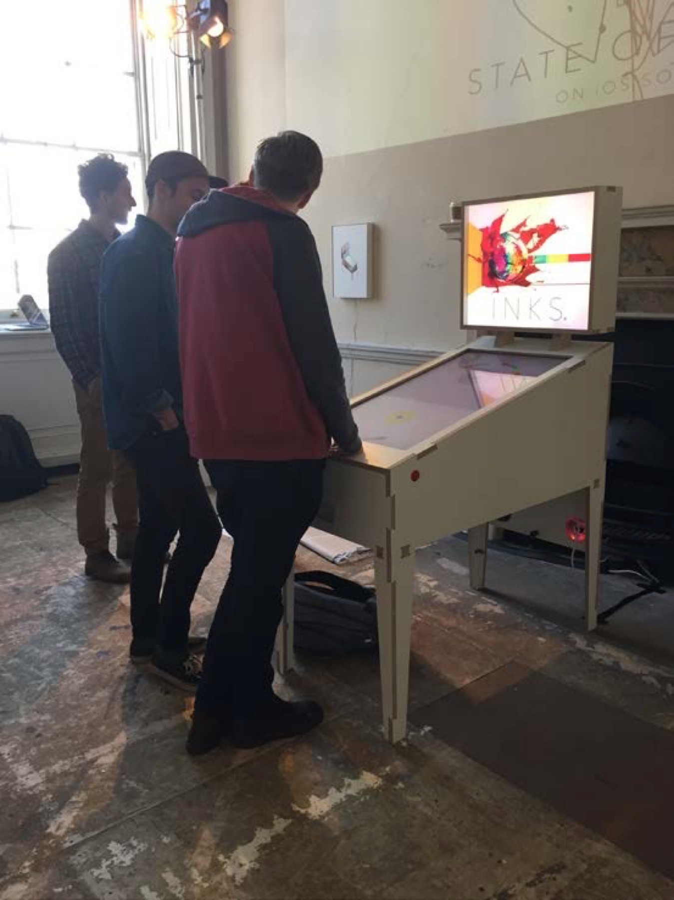Visitors gathered around the physical INKS table.